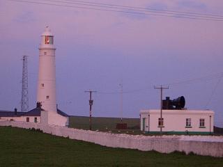 Lighthouse with the east or high light (originally painted black and white stripes) and fog horn at Nash Point